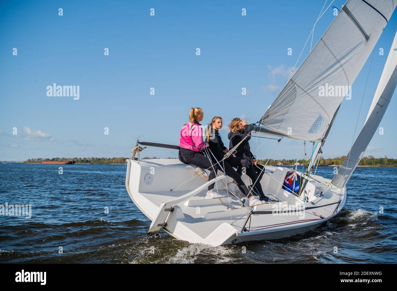 A Beautiful White Yacht Is Sailing In The Wind On The River Against The Background Of A Beautiful Autumn Forest A Guy On Board With Two Girls Stock Photo Alamy