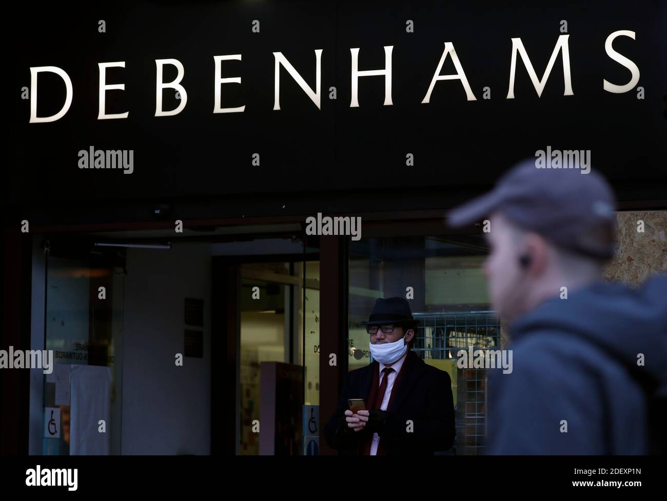 Nottingham, Nottinghamshire, UK. 2nd December 2020. A man stands outside a Debenhams store after the department store chain collapsed but opened its stores for a stock clearance sale. Credit Darren Staples/Alamy Live News. Stock Photo