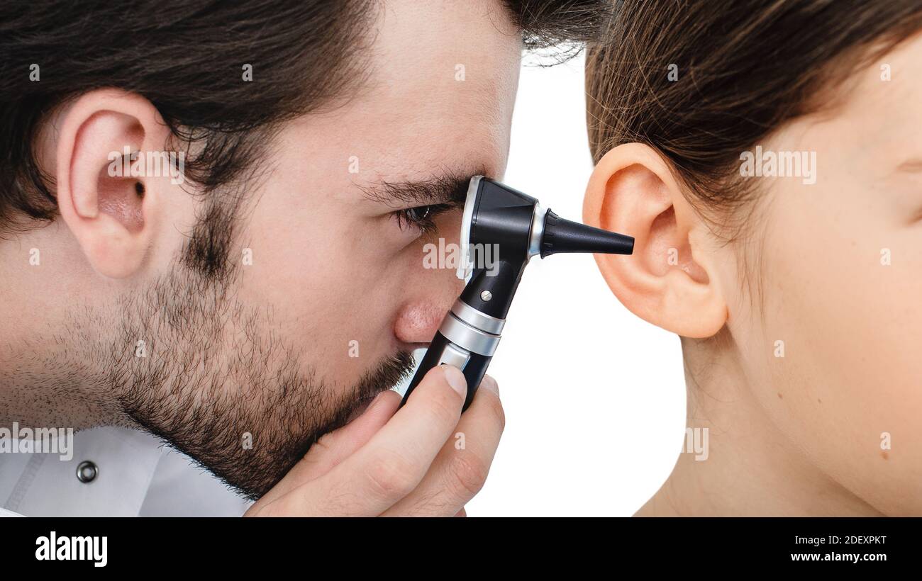 Otolaryngologist checking child's ear using otoscope. Hearing exam for