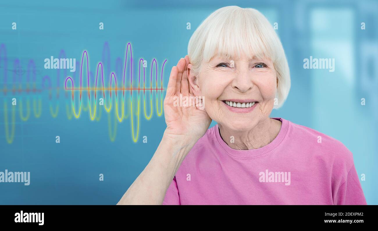 Concept lifestyle deaf elderly people. Smiling senior woman with a hand near ear listening sounds and voices, sound waves on background Stock Photo