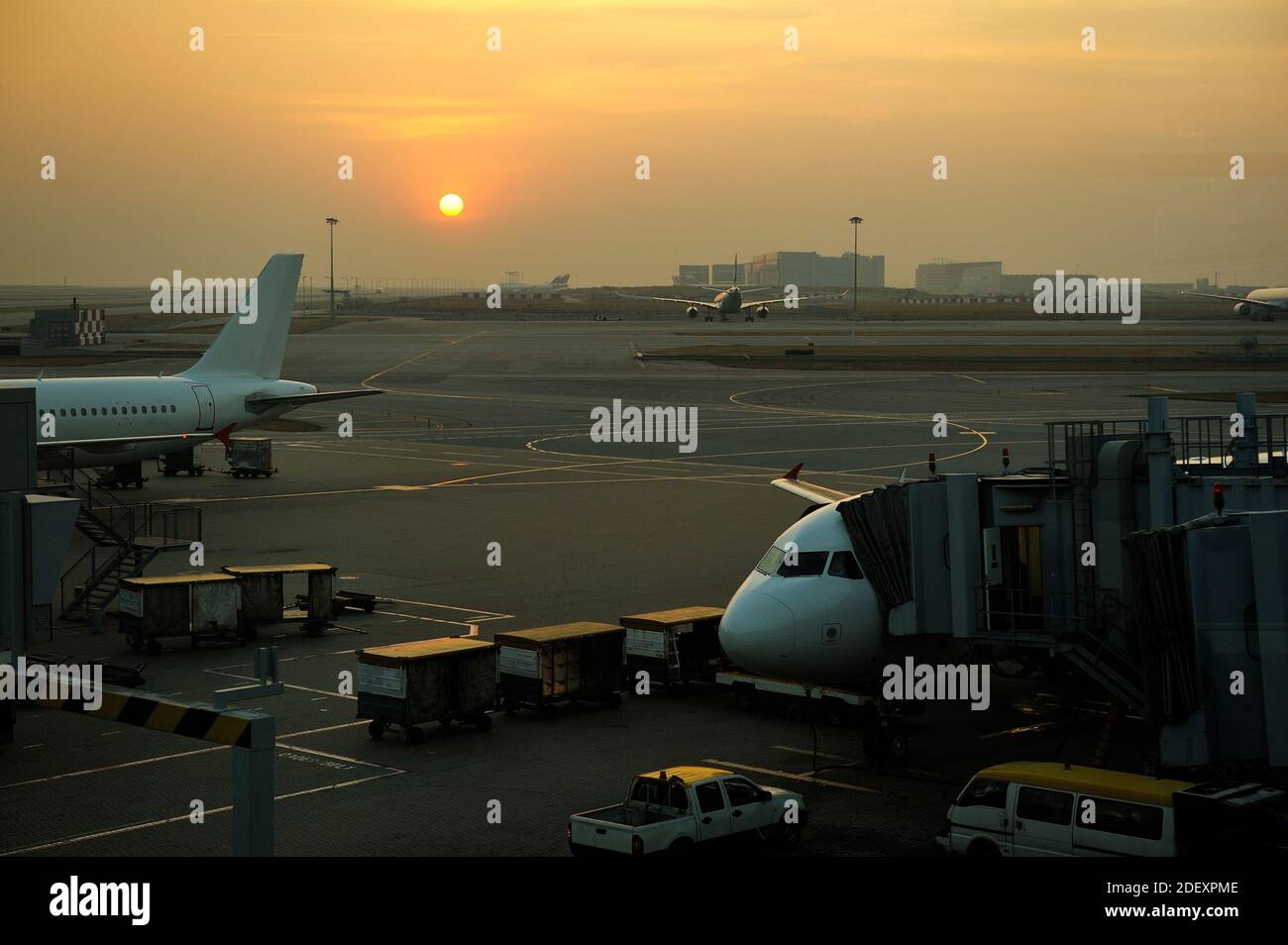 Planes on airport tarmac in dramatic sunset light Stock Photo - Alamy