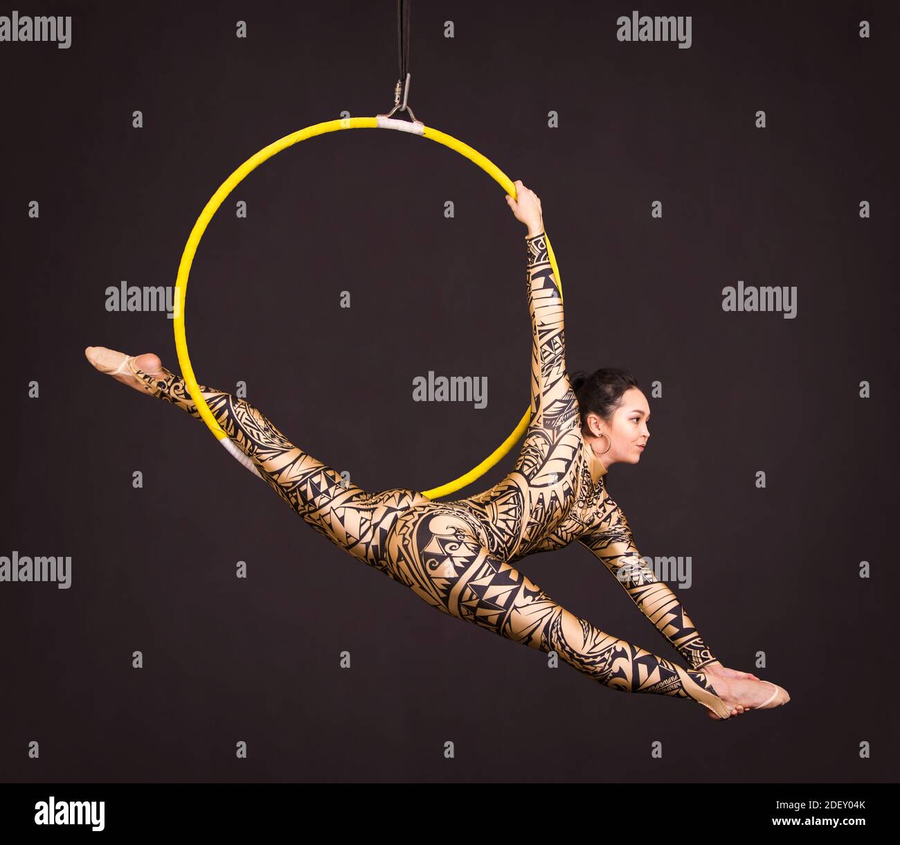 A young woman in a suit with a print performs acrobatic elements in the ...