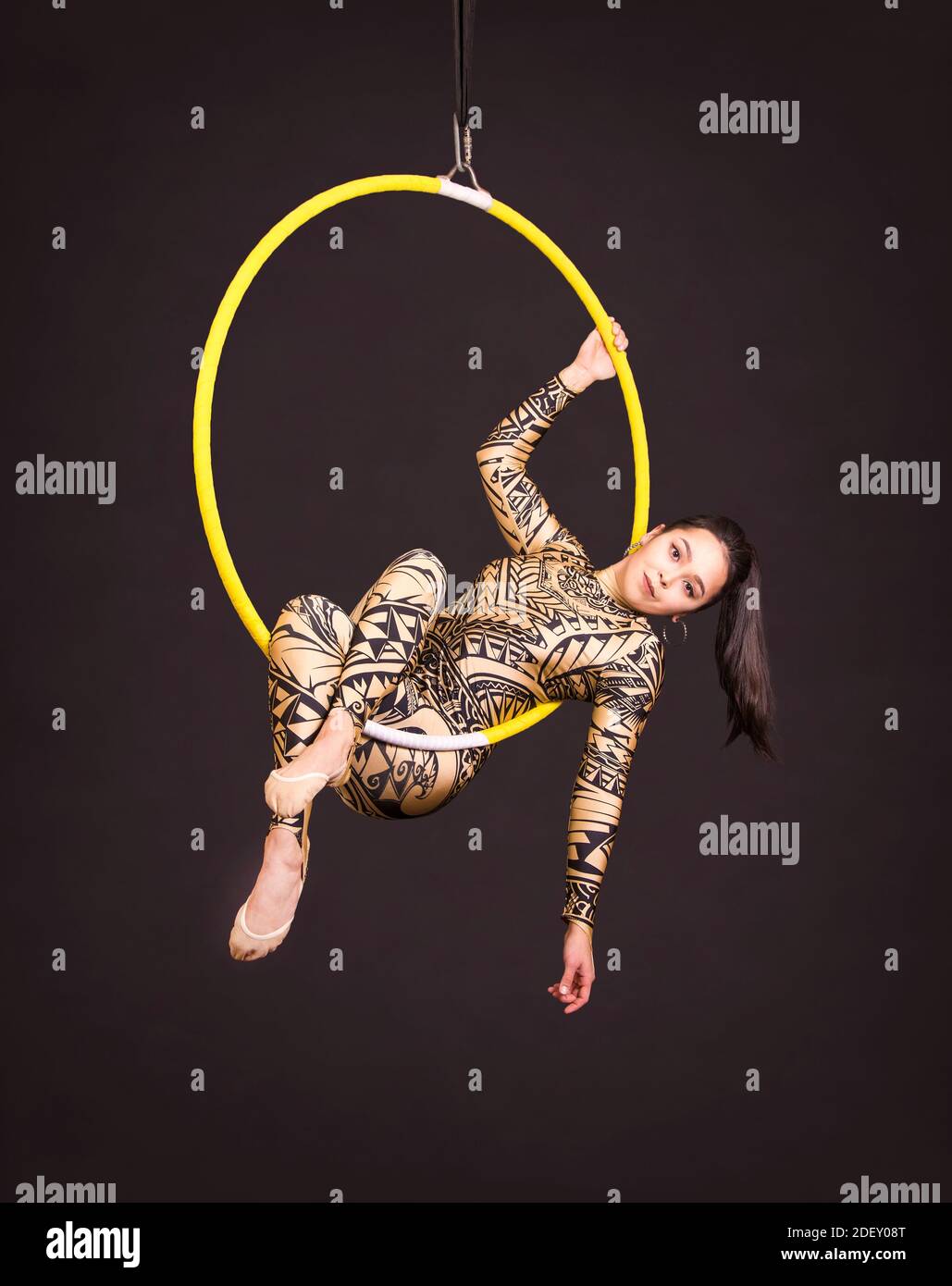 A young woman in a suit with a print performs acrobatic elements in the ...