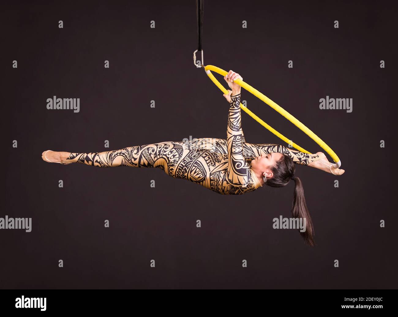 A young woman in a suit with a print performs acrobatic elements in the ...