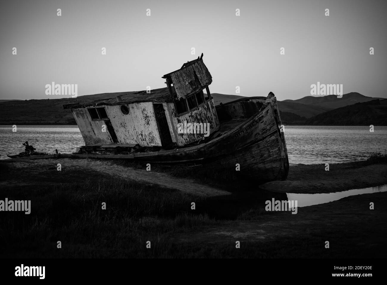 INVERNESS, UNITED STATES - Apr 14, 2020: An old classic fishing boat  abandoned on the shore in Tomales Bay Stock Photo