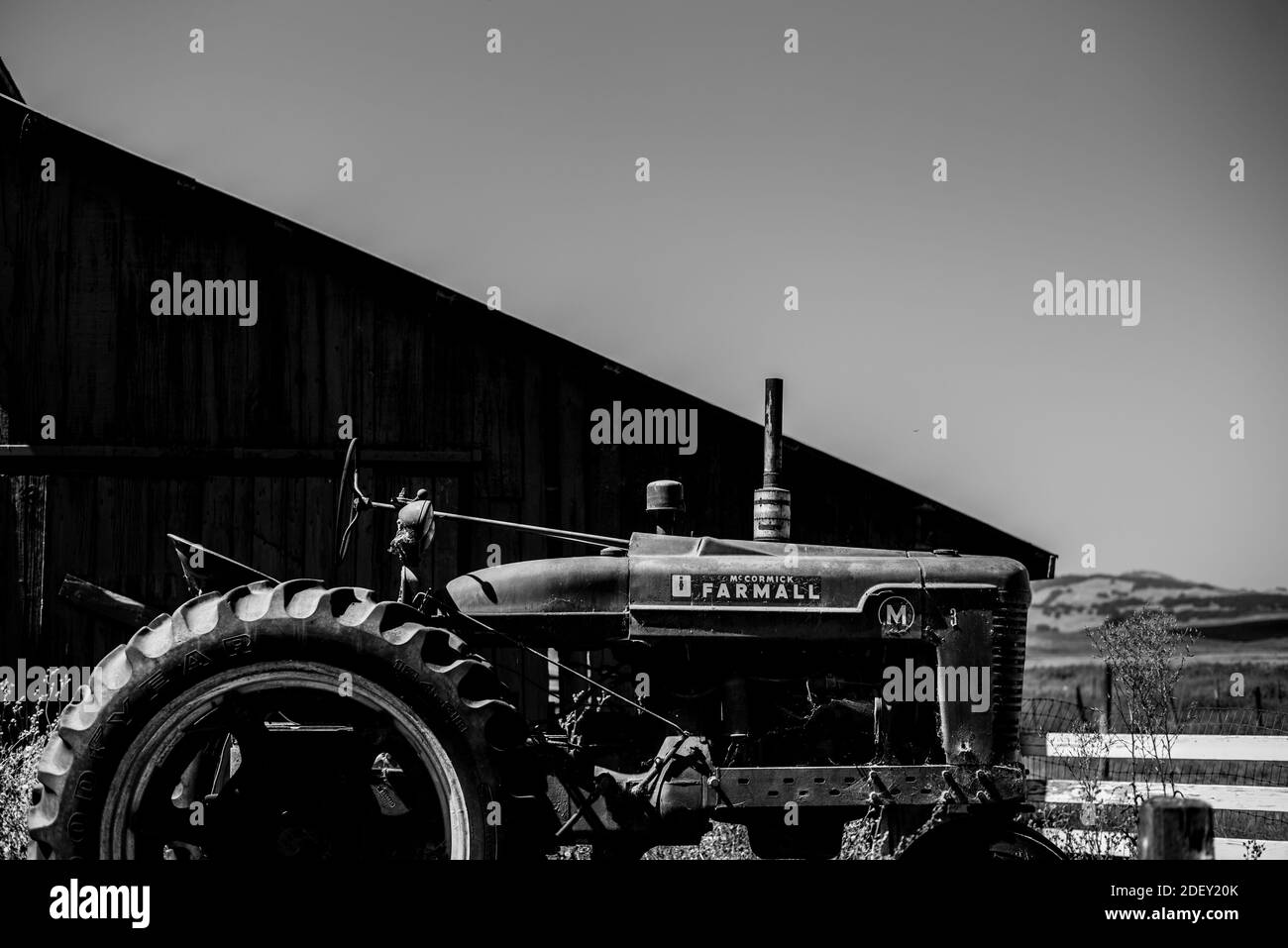 PETALUMA, UNITED STATES - Jul 17, 2019: An old tractor left next to a barn out in the open Stock Photo