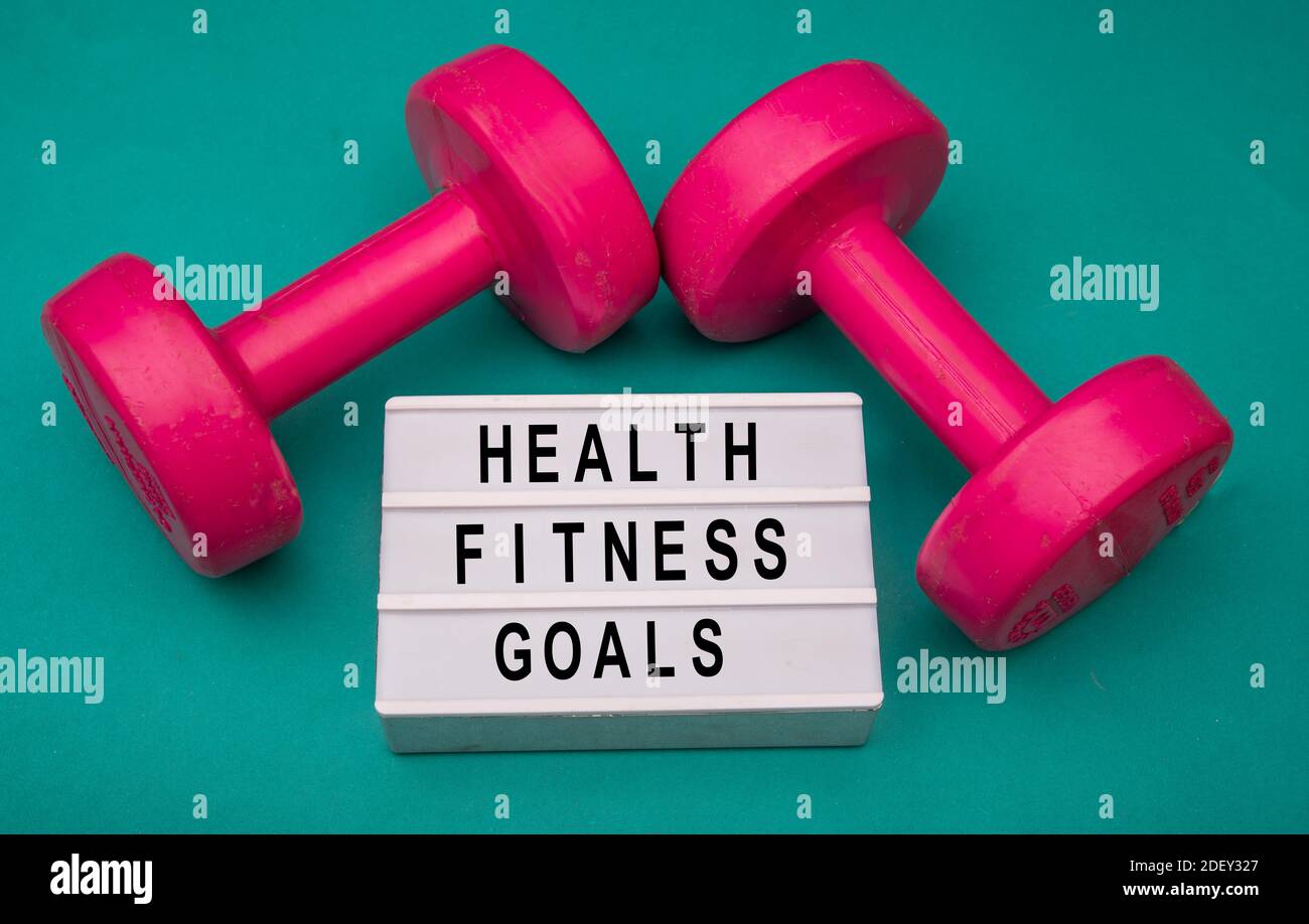 Health and Fitness goals sign with dumbbells around Stock Photo