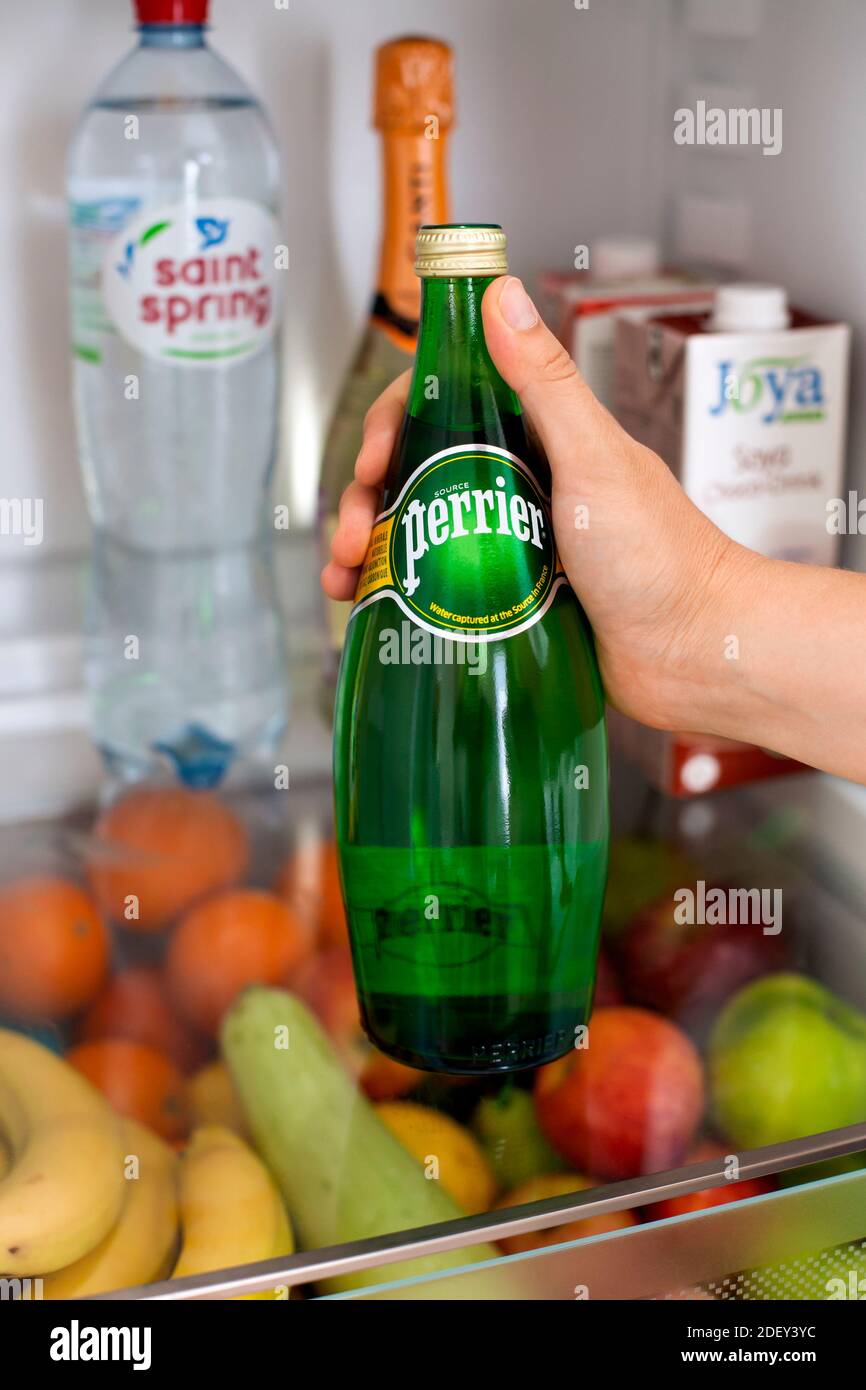 Tambov, Russian Federation - June 10, 2019 Woman hand taking bottle with Perrier water from fridge. Stock Photo