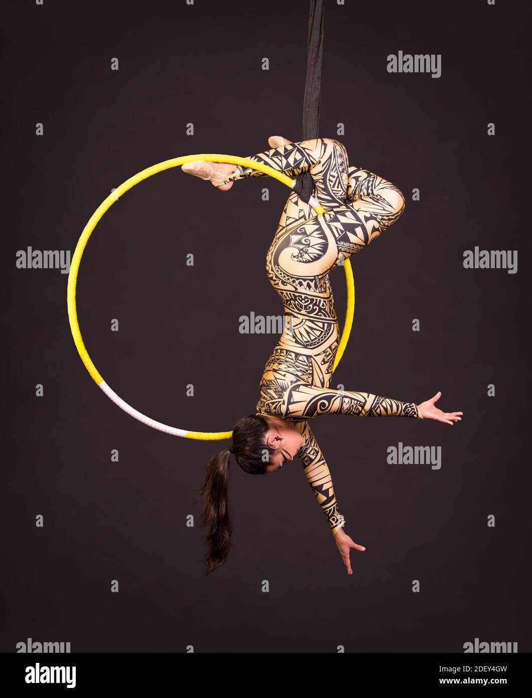A young woman in a suit with a print performs acrobatic elements in the ...
