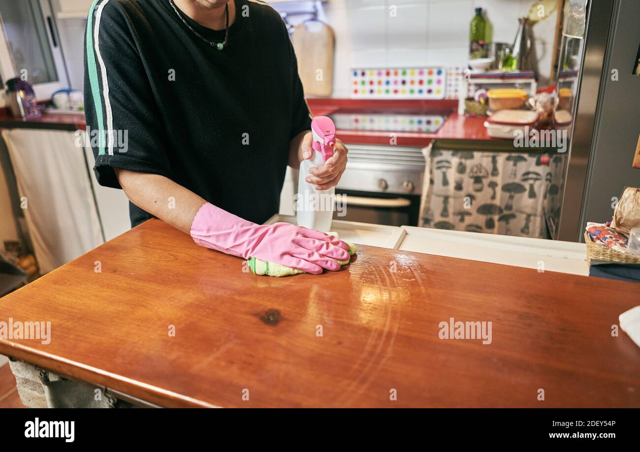 A low angle closeup of a female cleaning the kitchen table with
