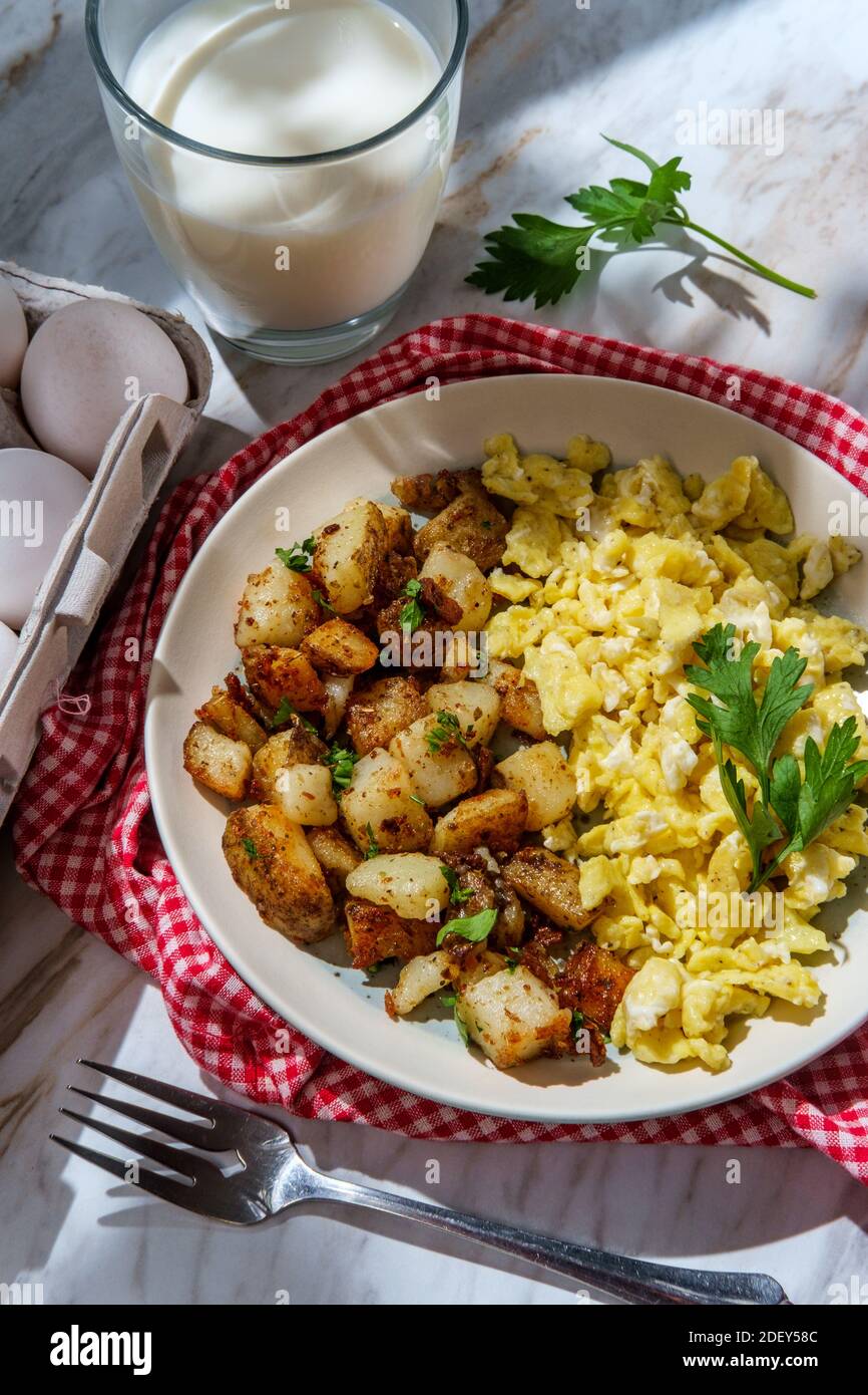 American scrambled eggs with home fries and milk a complete breakfast Stock Photo Alamy