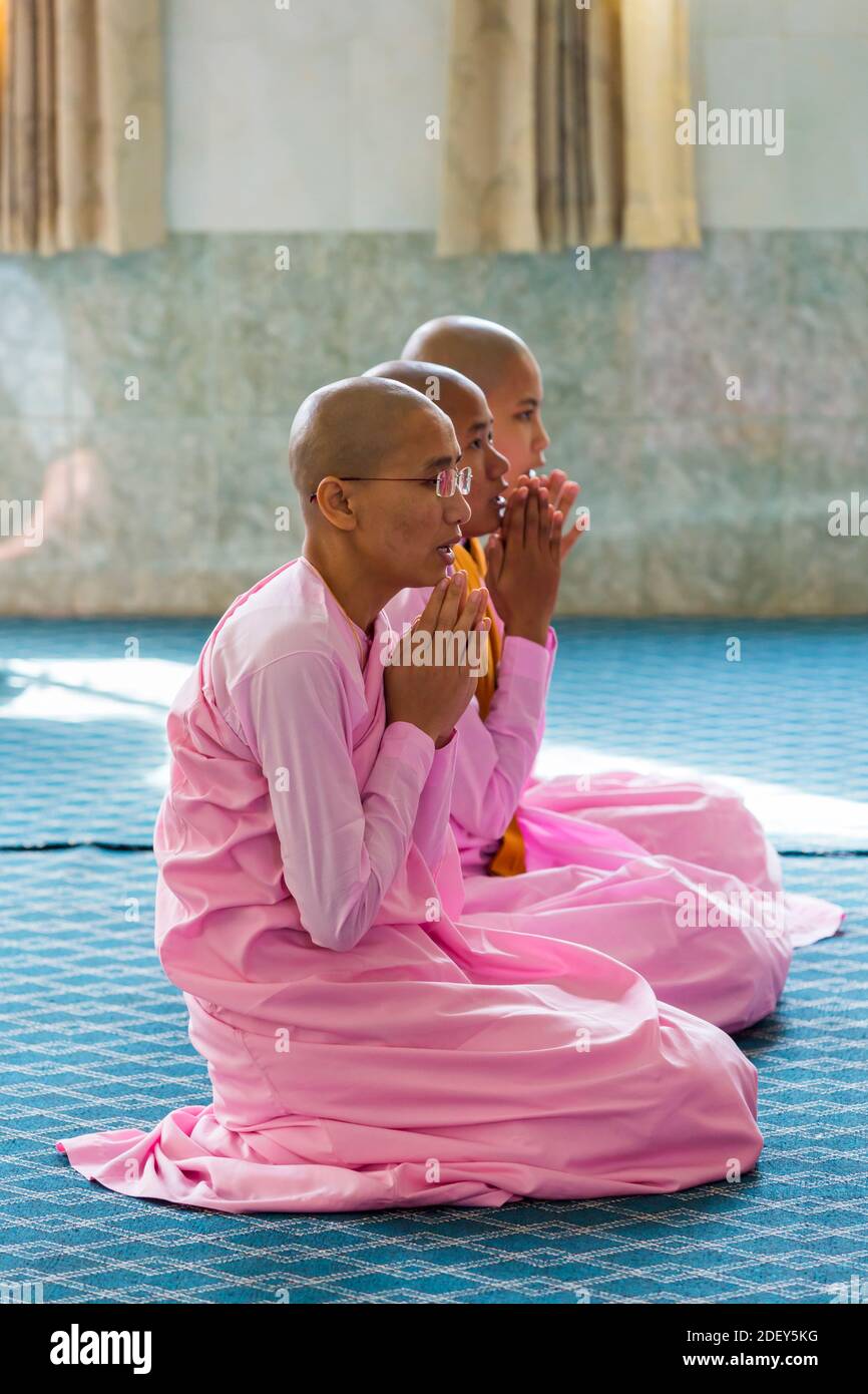 Buddhist nuns praying inside temple pagoda at Thetkya Thidar Nunnery
