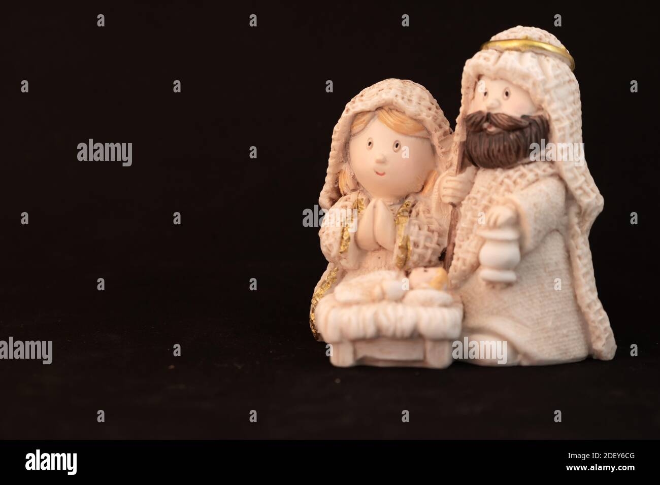 Representation of a Christmas nativity scene with the small figures of baby Jesus, Mary and Joseph on a rock background. Phrase space on the left. Chr Stock Photo