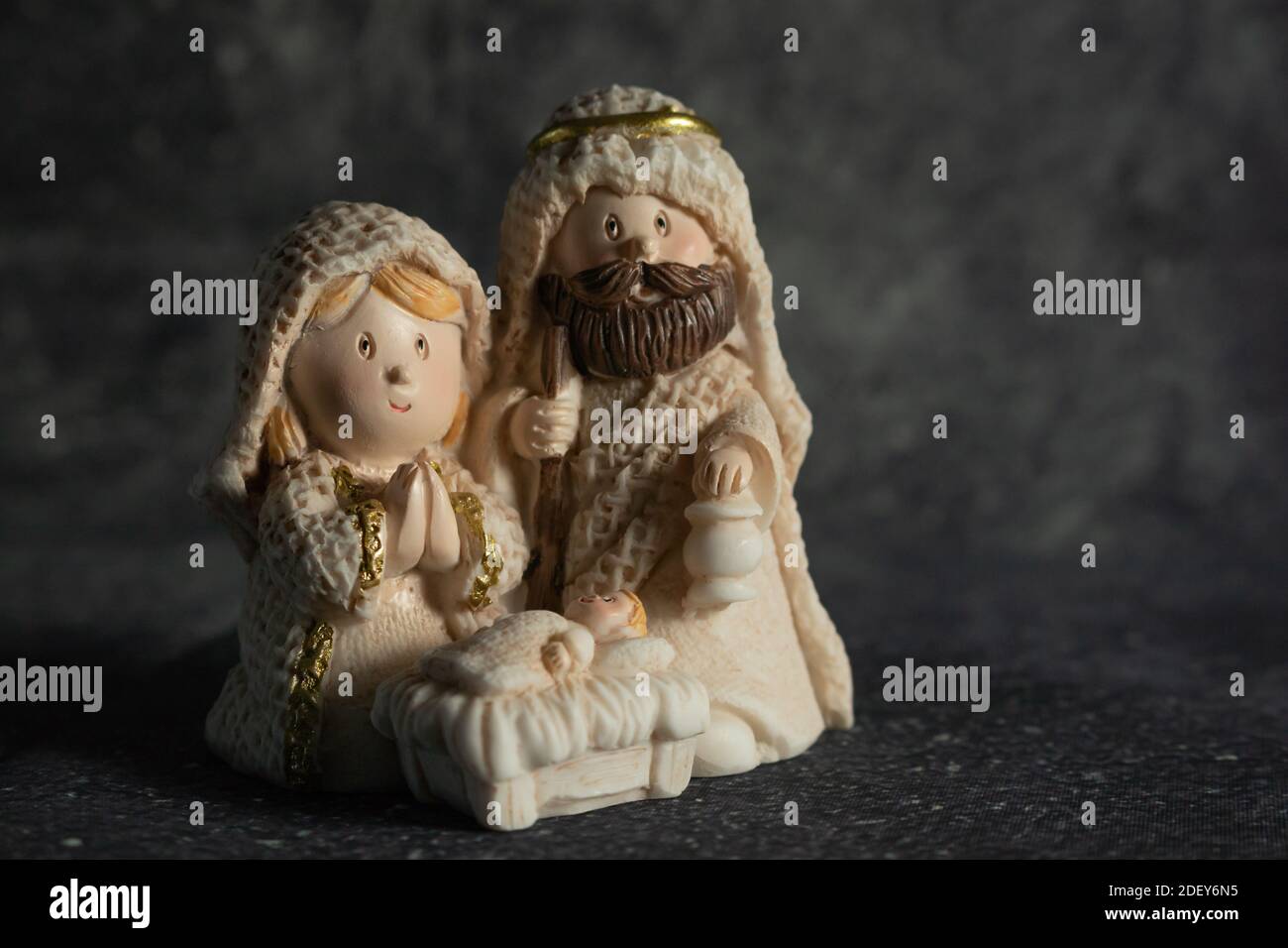 Representation of a Christmas nativity scene with the figures of baby Jesus, Mary and Joseph on a rock background. Phrase space on the right. Christma Stock Photo