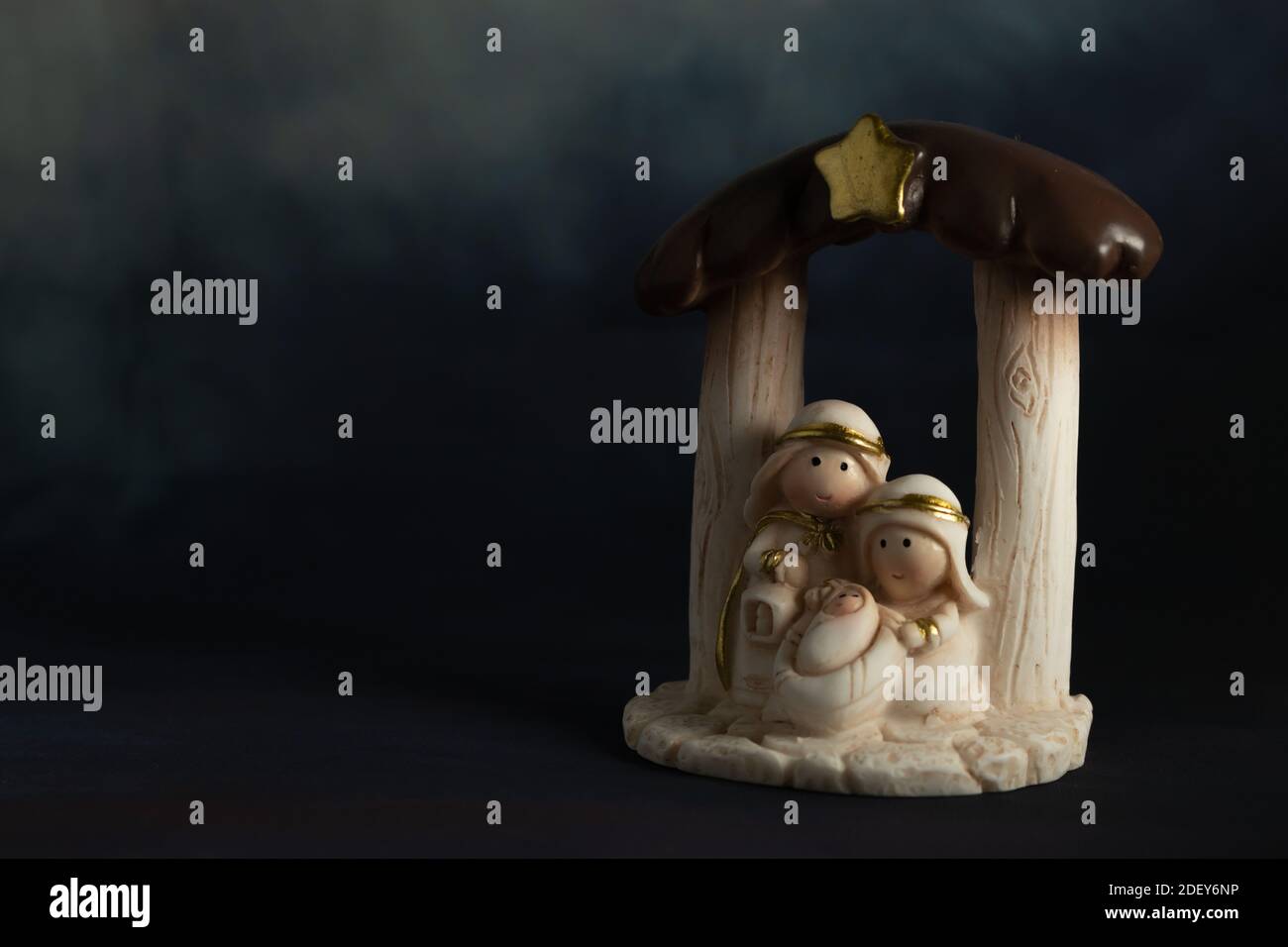 Representation of a Christmas nativity scene with the small figures of baby Jesus, Mary and Joseph on a rock background. Phrase space on the left. Chr Stock Photo