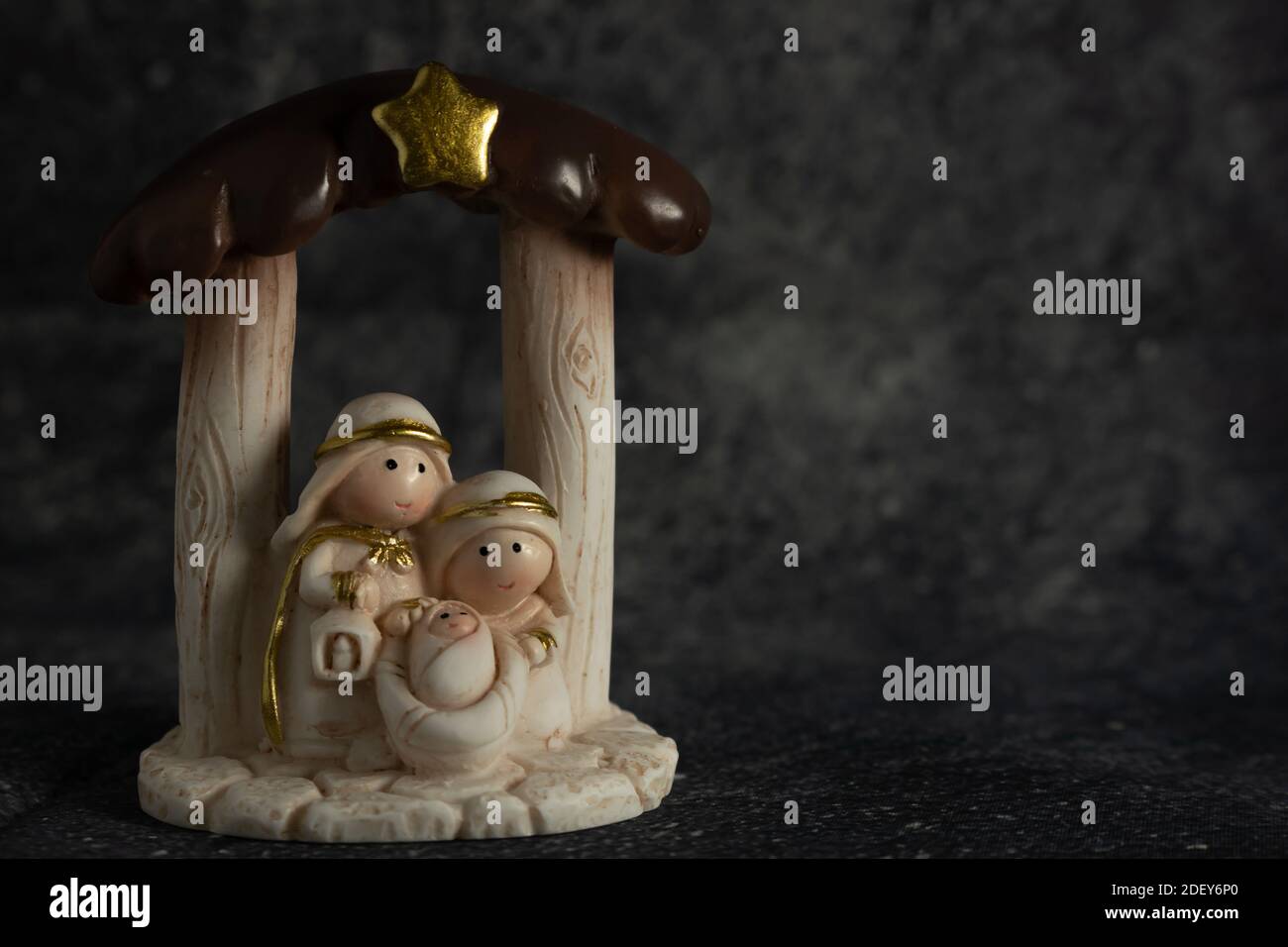 Representation of a Christmas nativity scene with the figures of baby Jesus, Mary and Joseph on a rock background. Phrase space on the right. Christma Stock Photo