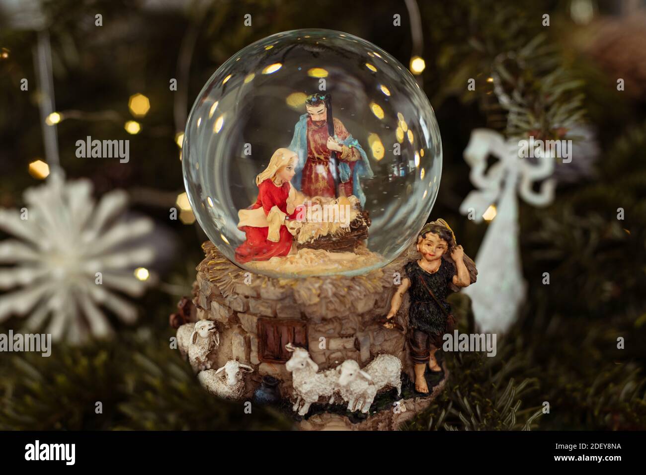 Scene of the birth of Jesus Christ in a glass ball on a Christmas tree ...