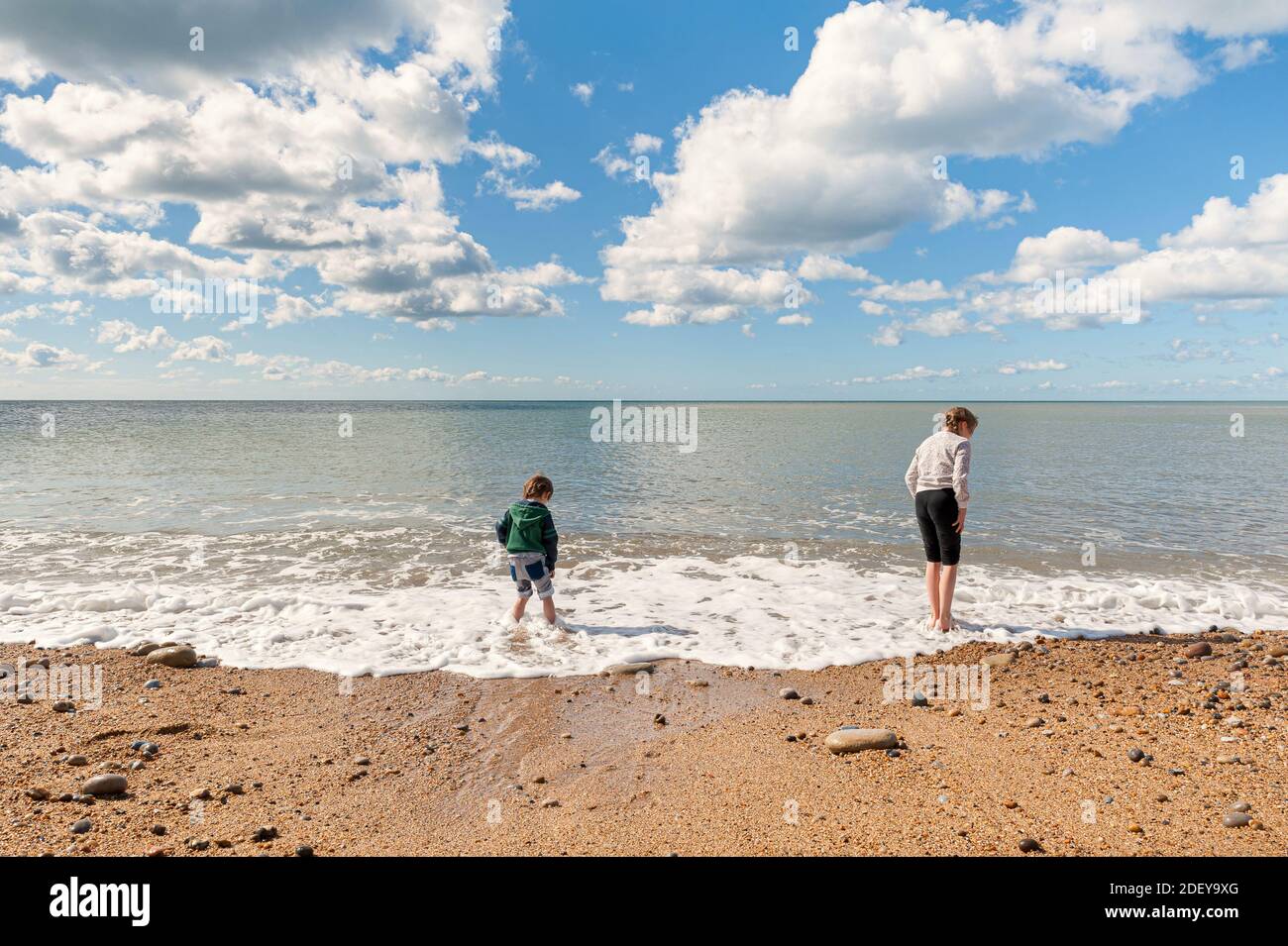 08-29-2020. Dorset, UK. Family day out at the beach during sunny but windy day. Children roaming wildly and enjoying their trip. Jurassic Cliffs Coast Stock Photo