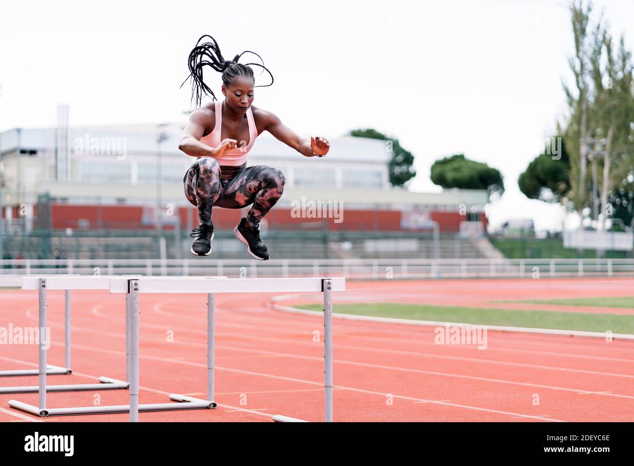 Stock photo of an African-American sprinter jumping a hurdle in the ...
