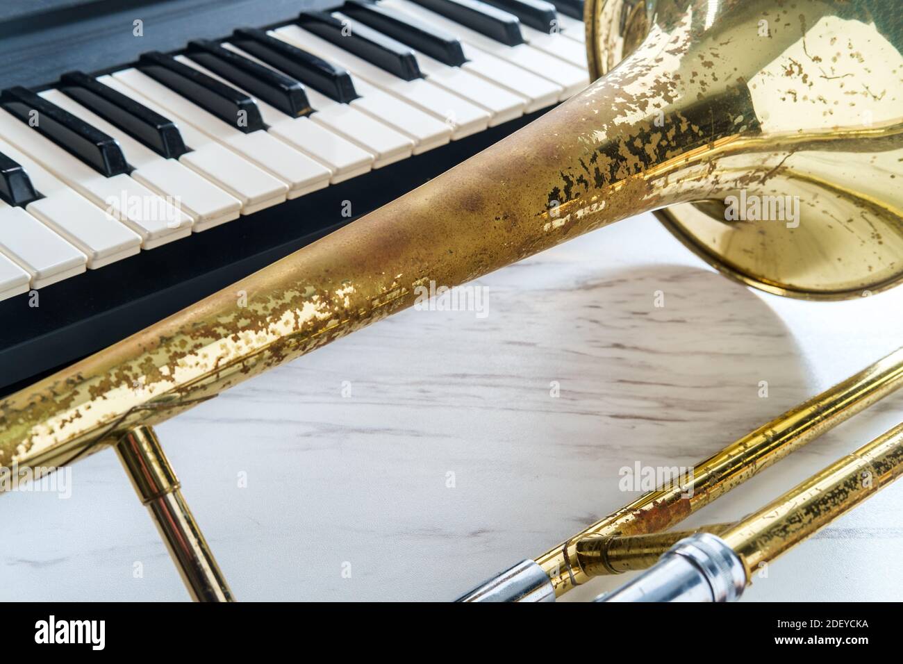 Rusty old classical trombone on marble table next to electric piano  keyboard Stock Photo - Alamy