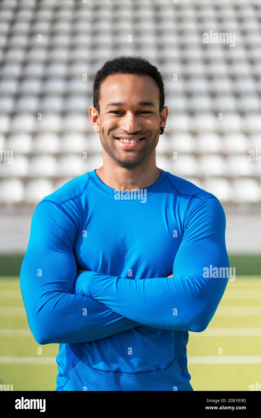 Stock photo of african american athlete in akimbo arms looking at camera in running track. Stock Photo