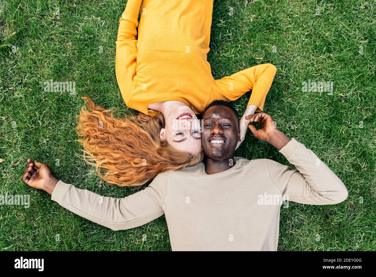 Stock photo of lovely young couple lying in the grass Stock Photo - Alamy