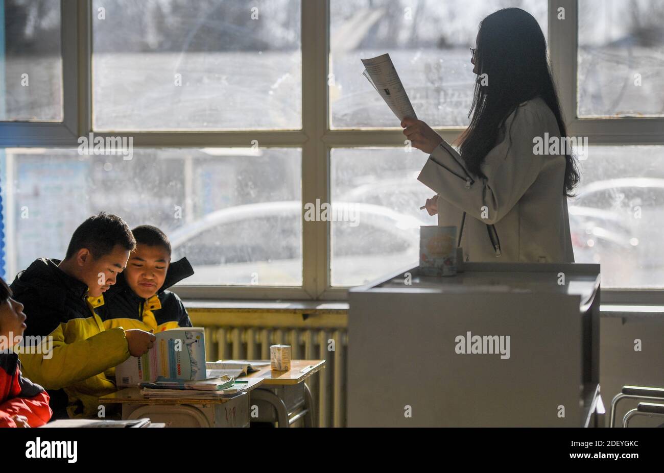 (201202) -- CHIFENG, Dec. 2, 2020 (Xinhua) -- Sun Simiao (1st, L) and Wang Aoran (2nd, L) are at class in the school in Chifeng City, north China's Inner Mongolia Autonomous Region, Nov. 25, 2020. Wang Aoran, 15, has been disabled in action by creatine kinase abnormality since he was a child. When in the second grade of primary school, he received help from schoolmate Sun Simiao, who voluntarily began to carry him from the school gate to his classroom. He has been helping him ever since. The two became inseparable best friends. They went to the same middle school, both in the same class Stock Photo