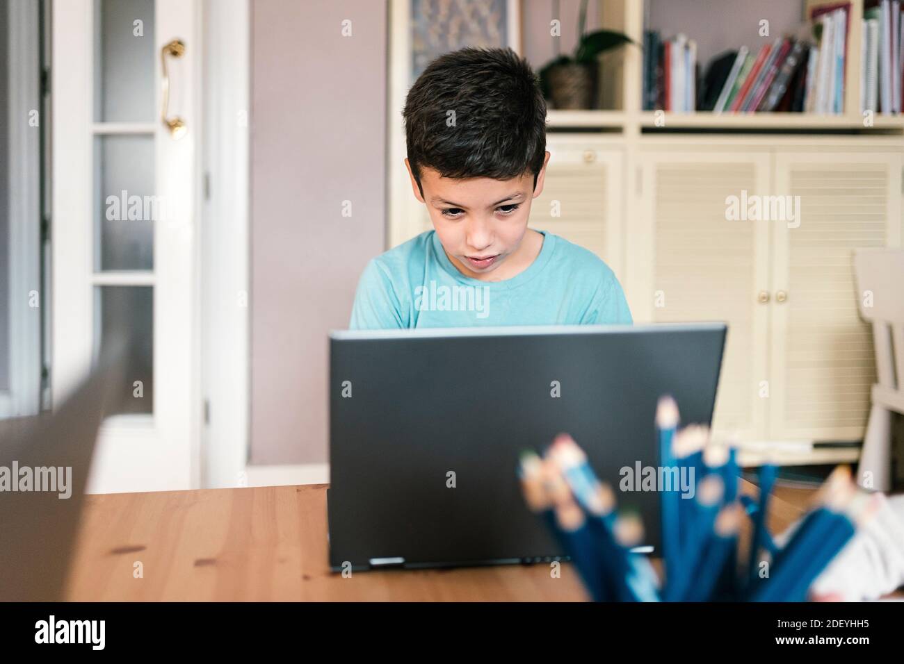 Stock photo of cute boy using laptop while sitting in the living room ...