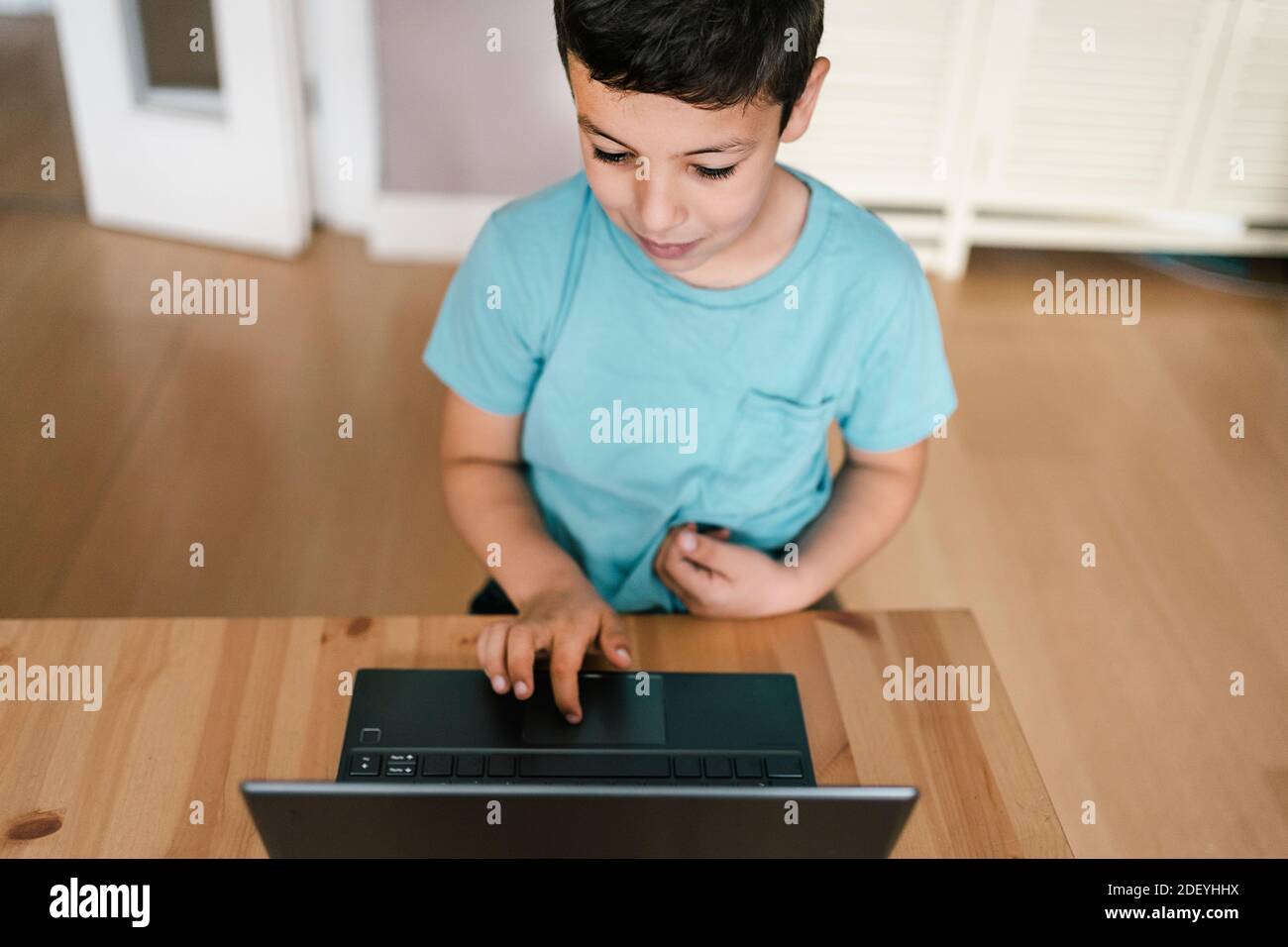 Stock photo of cute boy using laptop while sitting in the living room ...