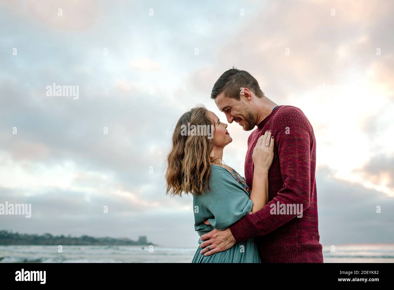 Loving gaze between husband and wife by the  ocean at sunset Stock Photo
