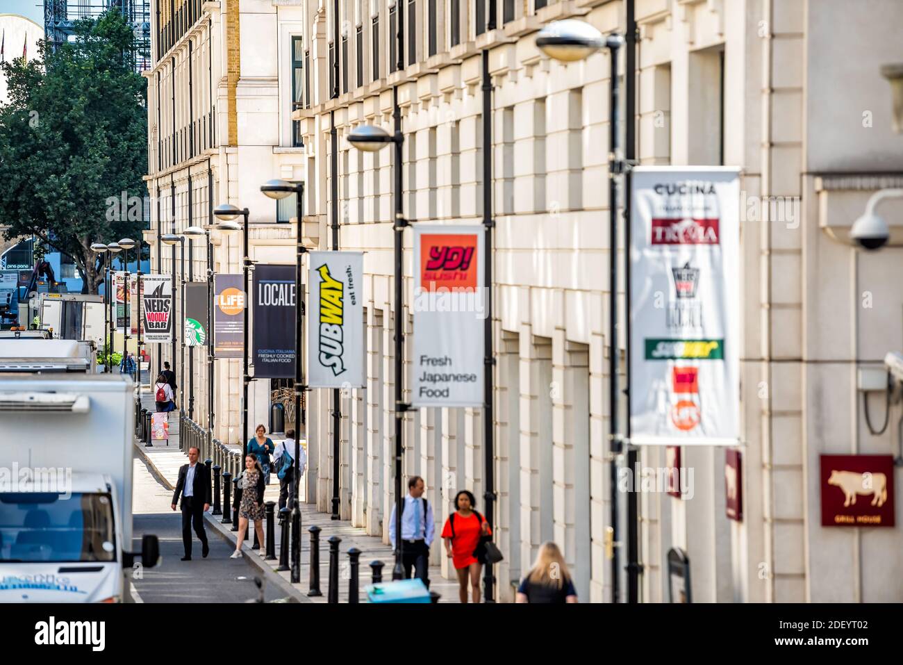 London, UK - June 22, 2018: Above high angle view on pedestrians people walking on street sidewalk and banners signs for restaurants such as Subway Stock Photo