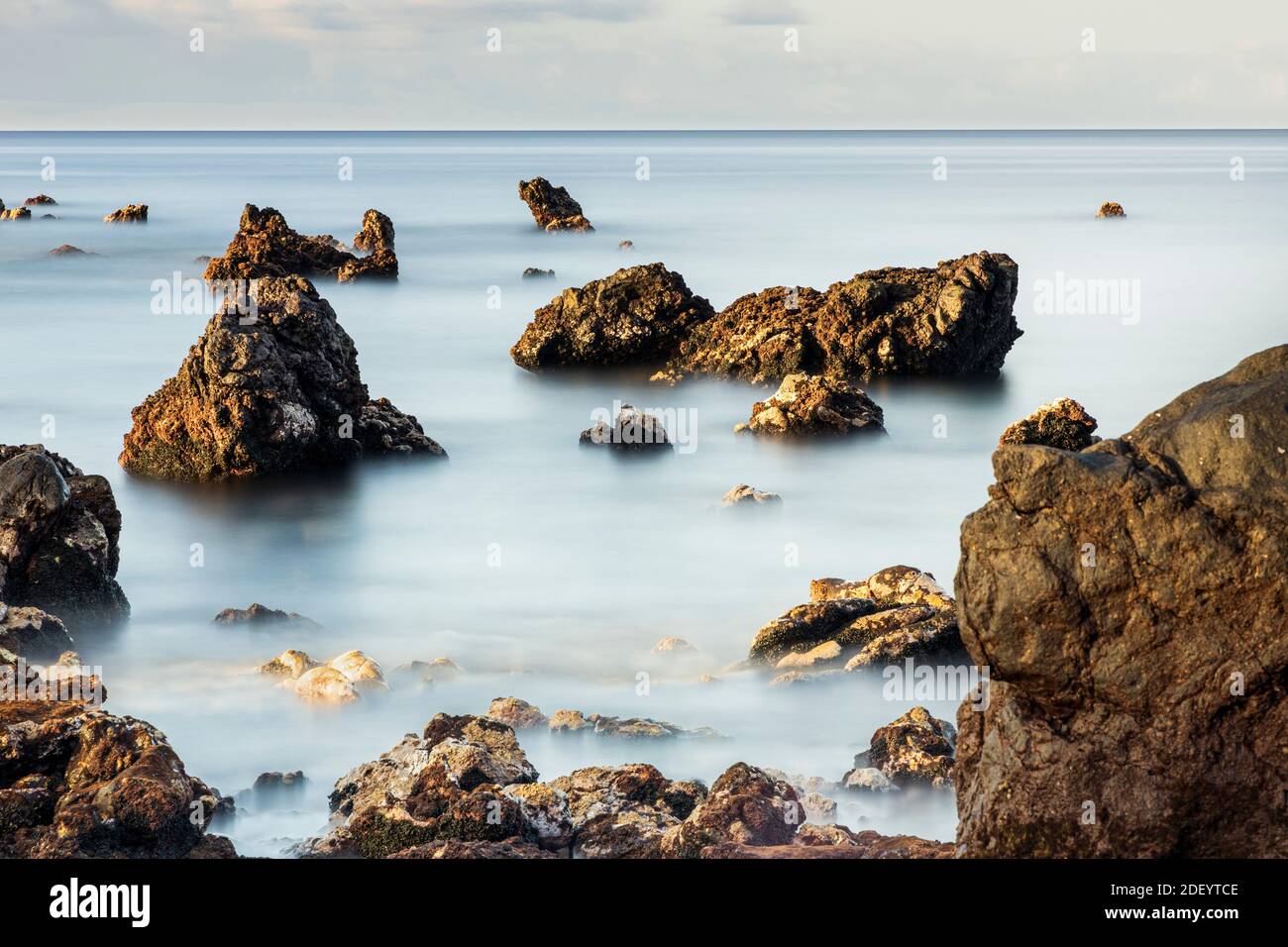 Long exposure seascapes at dawn with rocks at Playa san Juan, Tenerife, Canary Islands, Spain. Stock Photo