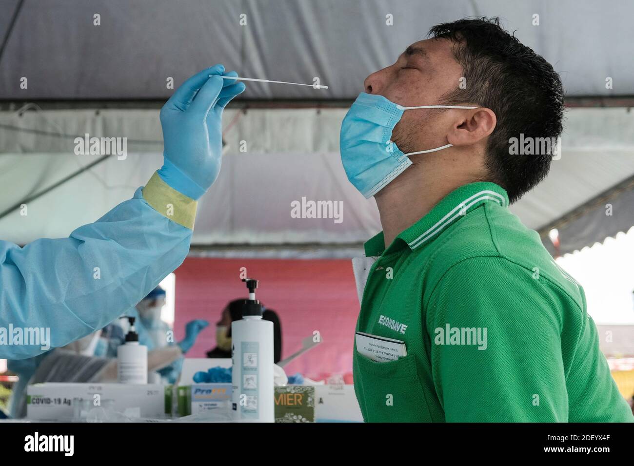 Klang, Malaysia. 02nd Dec, 2020. A medical healthcare worker wearing a personal protective equipment (PPE) takes a nasal swab sample from a foreign worker during the test.Selangor has conducted targeted community screening on residents around Meru, Klang following a spike of Covid-19 positive cases in the Teratai cluster. The Teratai cluster involves factory workers from Top Glove. Credit: SOPA Images Limited/Alamy Live News Stock Photo