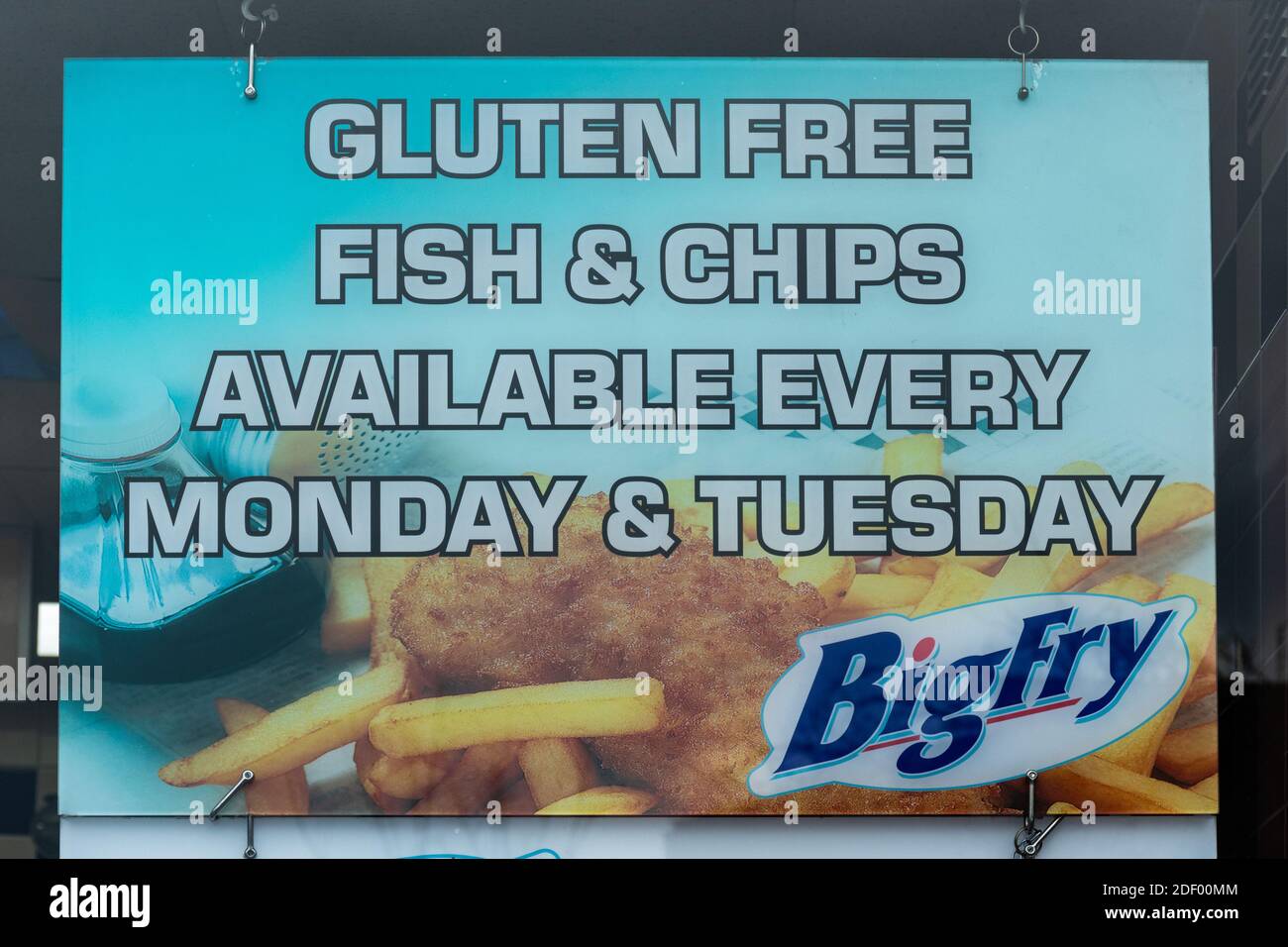 Sign about gluten free fish and chips displayed in the window of  takeaway chip shop, UK Stock Photo