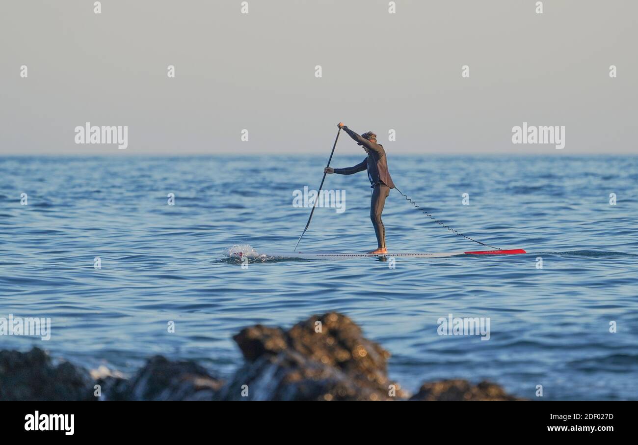 A man on open sea stand up paddleboarding, Spain. Stock Photo