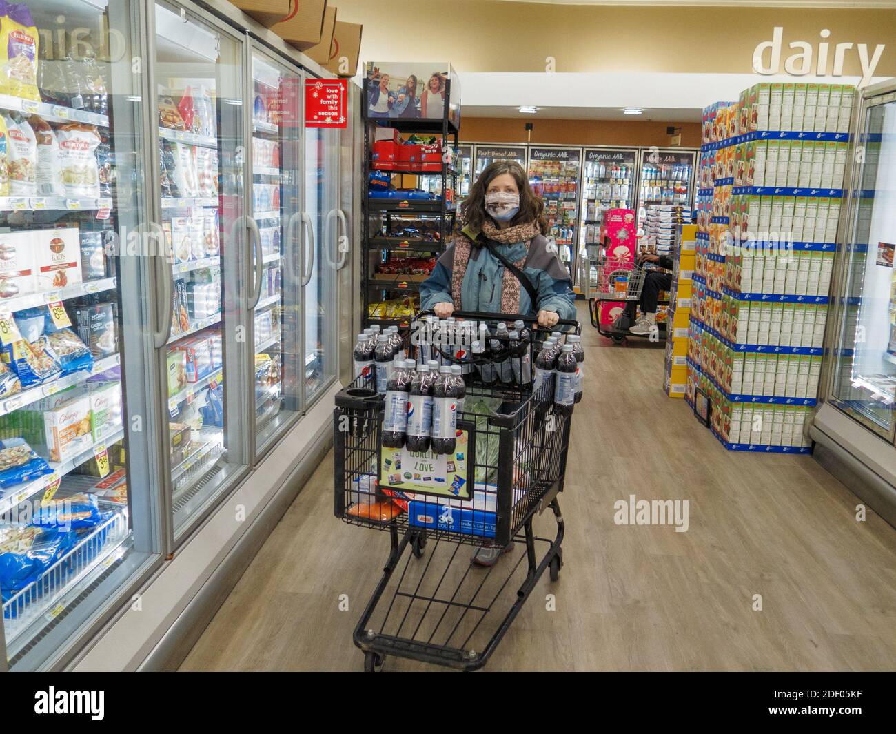 Woman wearing face mask while grocery shopping during COVID-19 pandimic. Chicago area, Illinois. Stock Photo