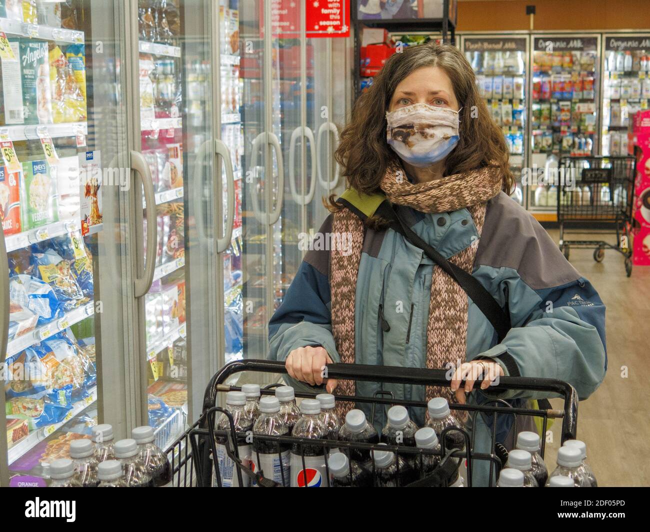 Woman wearing face mask while grocery shopping during COVID-19 pandimic. Chicago area, Illinois. Stock Photo