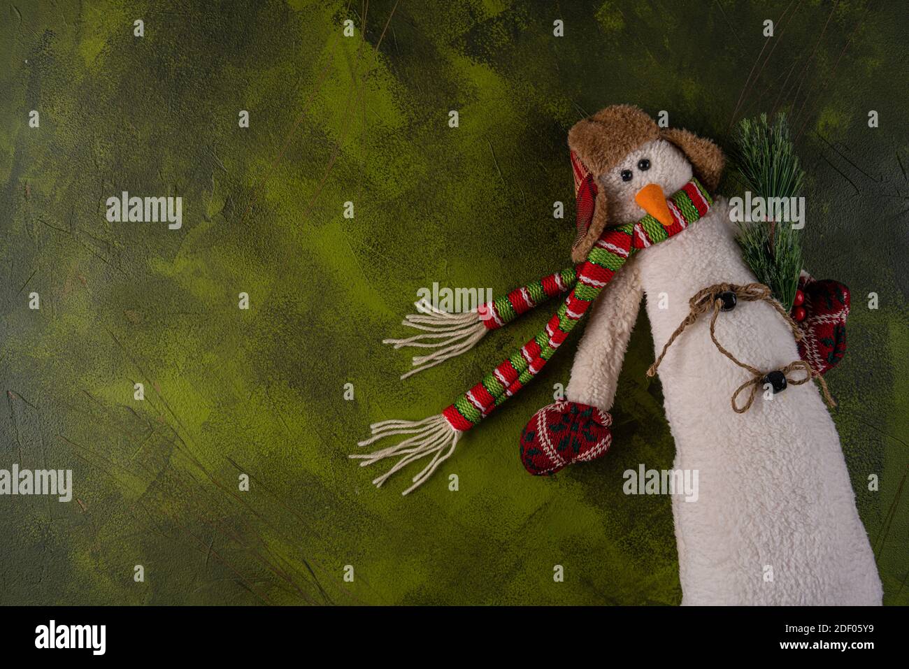 soft toy snowman on a green background Stock Photo