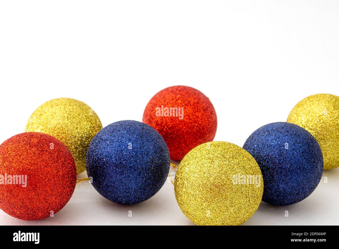 Christmas balls blue, red and yellow color on white background. Selective focus, copy space Stock Photo