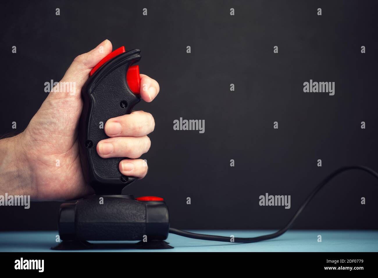 A person playing video games with a retro joystick from the mid-1980s. Close up. Stock Photo