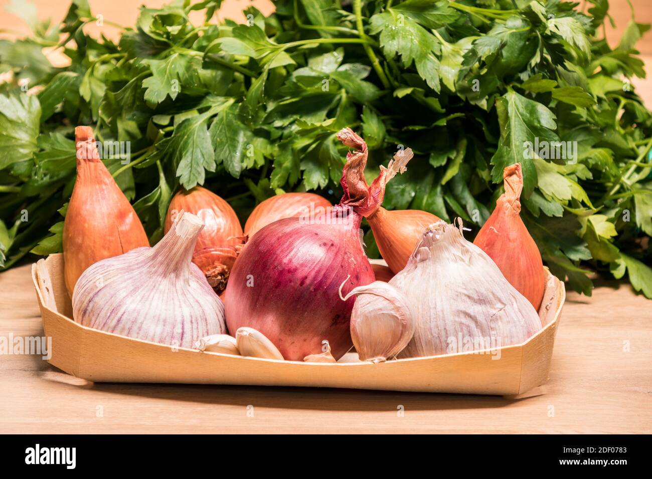 garlic onions shallots in a small wooden basket and parsley Stock Photo ...