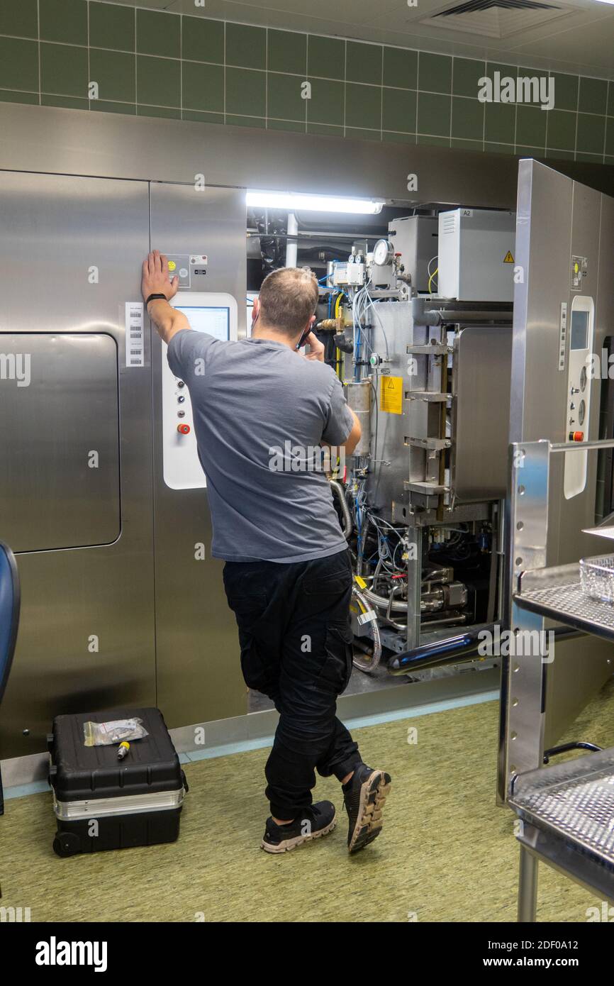 a customer service representative repairs a steam sterilizer in a