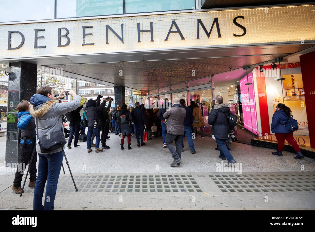 London, UK. - 2 Dec 2020: Media surround people entering the Debenhams store on Oxford Street, the first trading day since the chain announced it intends to shut all its stores. Stock Photo