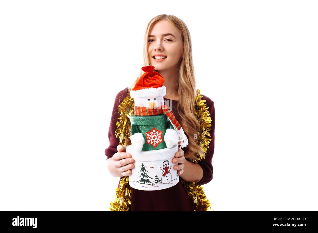 Happy young woman in Santa Claus hat, in hands, a gift box on a white ...