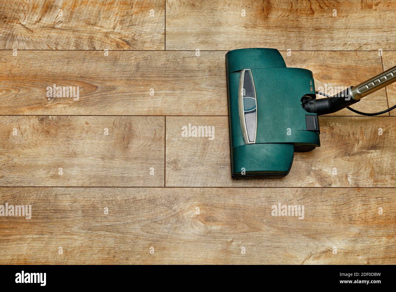Remove dust from wood textured floor with a vacuum cleaner, copy space