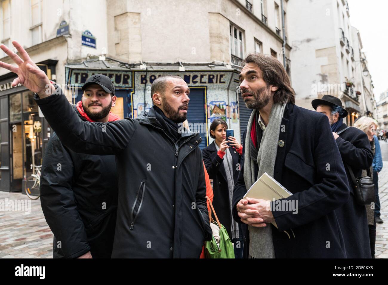 Cedric Villani (R.), dissident candidate from La Republique en Marche  (LREM) as mayor of Paris, talks with a worker from l'As des Falafels during  his visit to the shops of the Rue