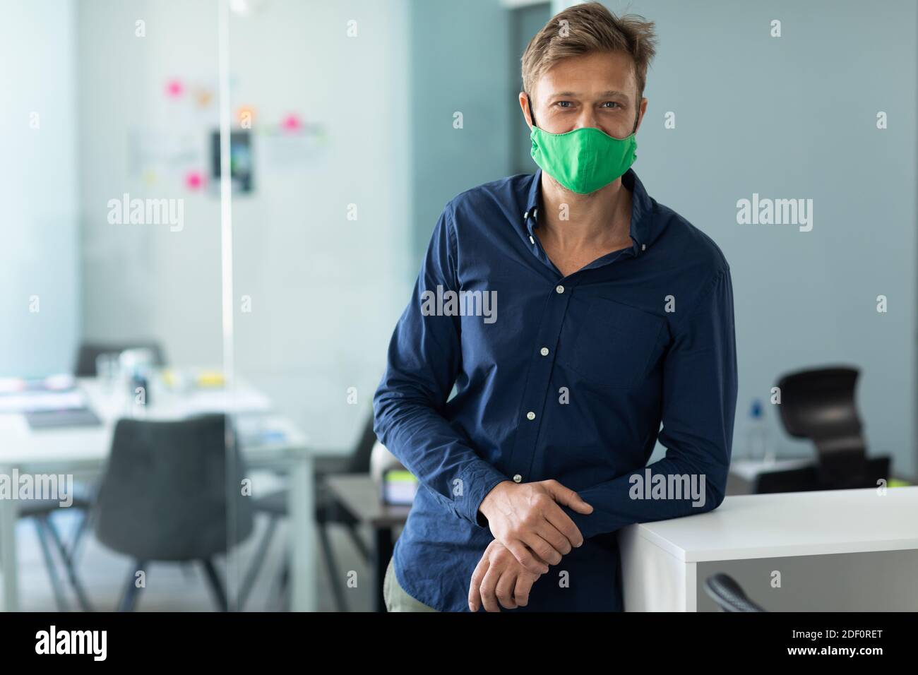 Caucasian man wearing face mask in an office Stock Photo