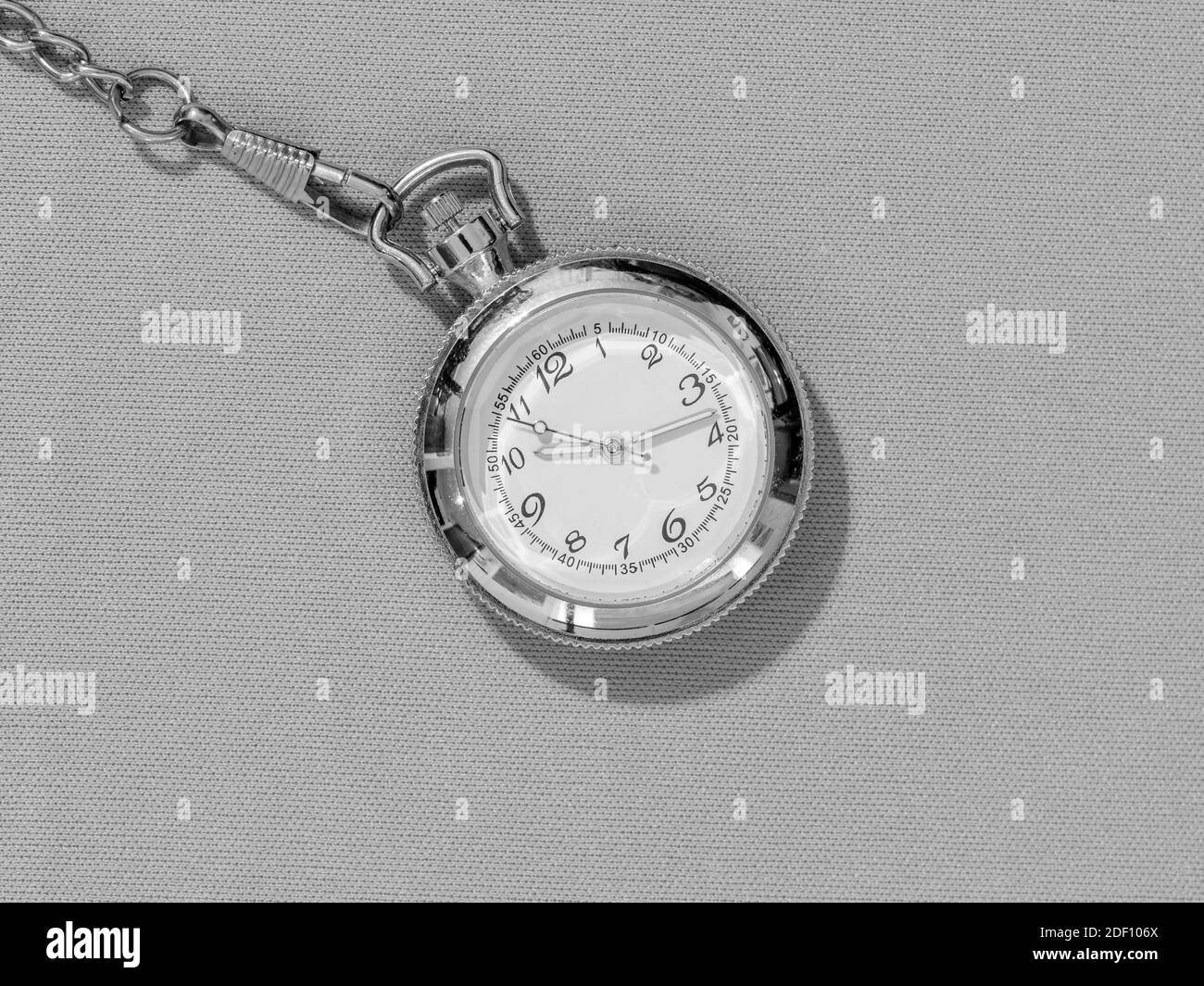 Small steel pocket watch with white dial, black and white image of