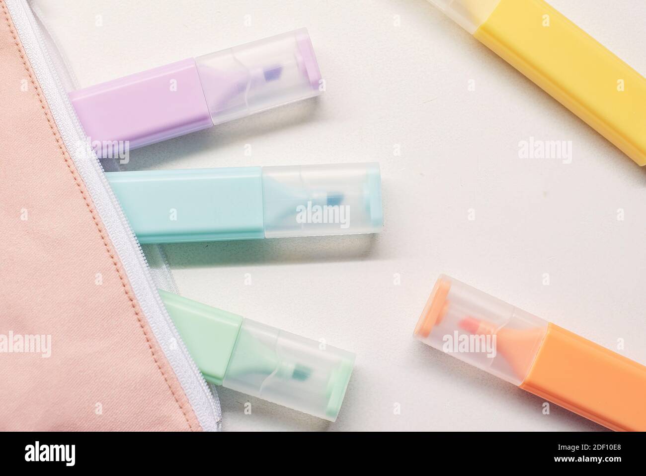 Pastel colored pens and school pencil case on white background Stock Photo
