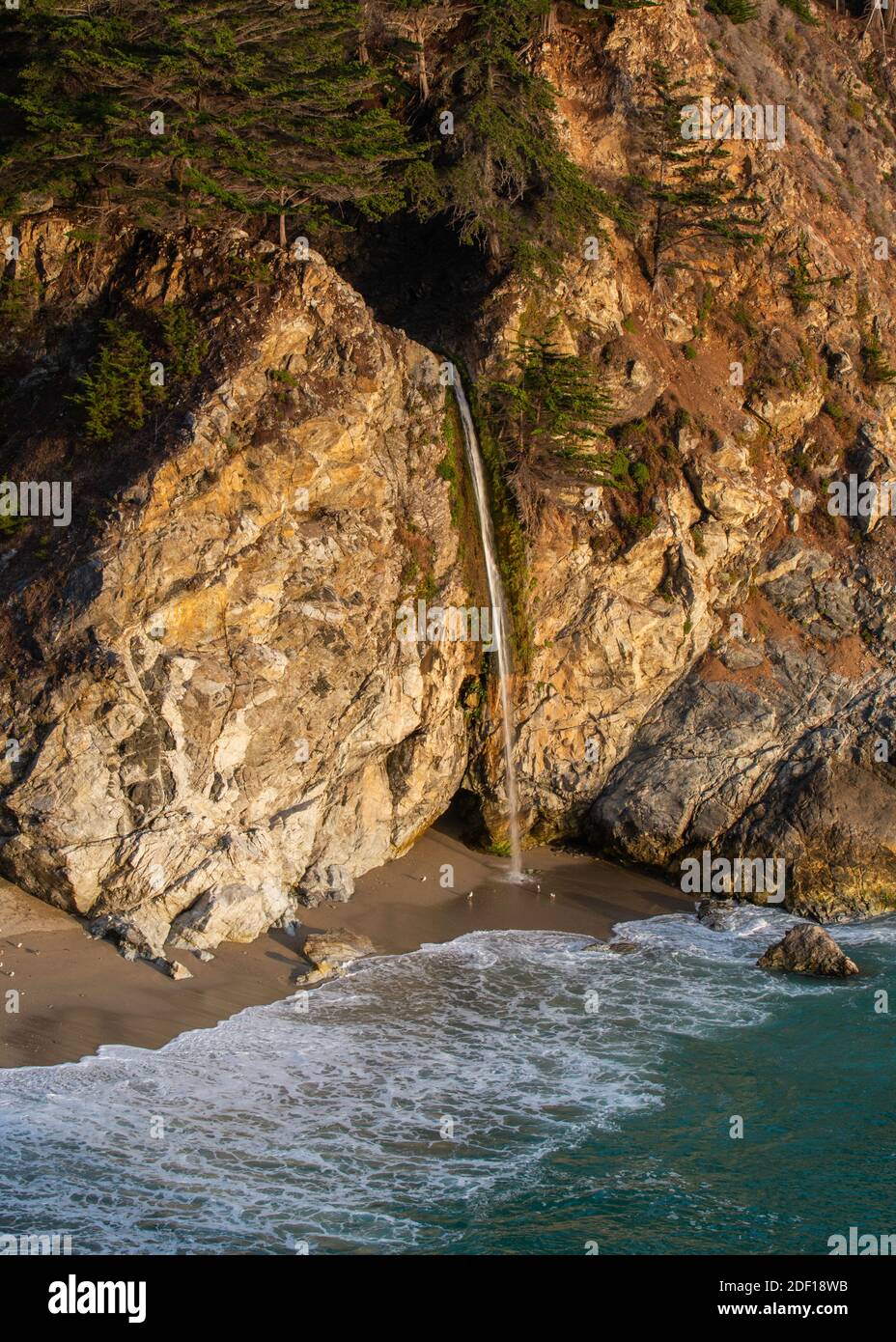 Waterfall outlet right onto the beach at Pfeiffer Big Sur State Park Stock Photo